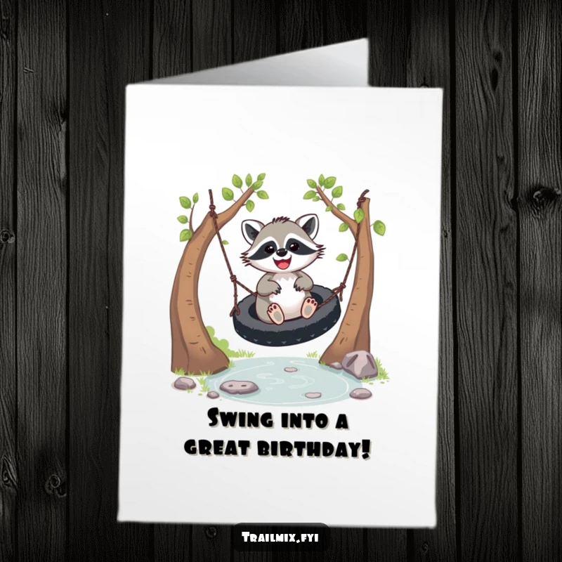 Funny free printable birthday card showing a gleeful raccoon joyfully swinging on a tire over a sparkling stream, ready to party.