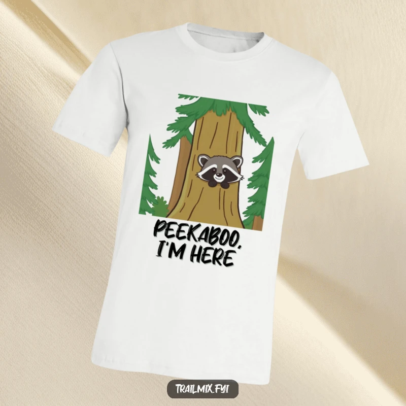 Funny t-shirt features a grinning raccoon peeking from behind a tall pine, radiating infectious giggles and forest charm.